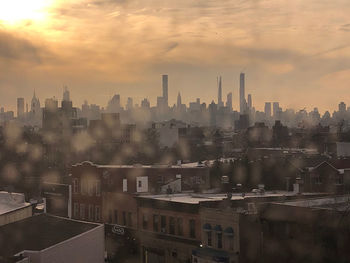 Buildings in city against sky during sunset