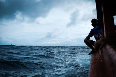 Man surfing in sea against sky