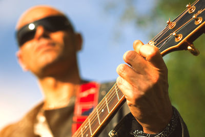 Close-up of man playing guitar