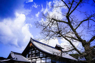 Low angle view of trees and building against sky