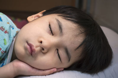 Close-up of young woman sleeping on bed