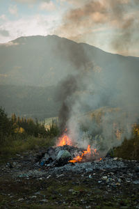 Scenic view of fire on mountain against sky