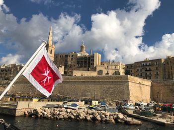 Flag against built structure against sky