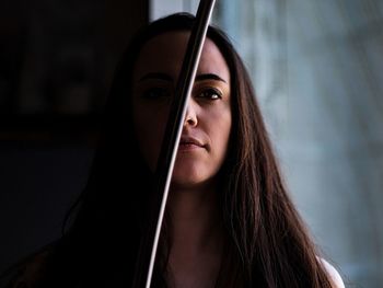 Portrait of young woman by metal rod at home