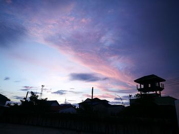 Low angle view of silhouette houses against sky during sunset