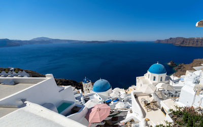 Panoramic view of oia town in santorini island with old whitewashed houses and typical blue domes 
