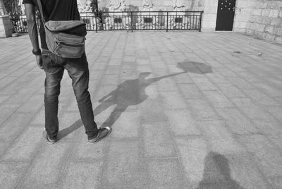 Low section of man with shadow on floor