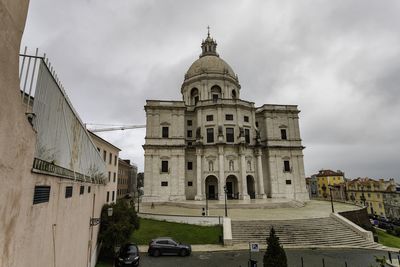 View of buildings in city against cloudy sky