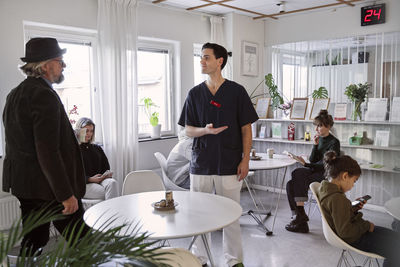 Doctor talking to patients in waiting room