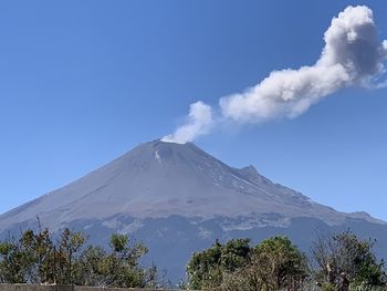 Scenic view of snowcapped mountains against blue sky