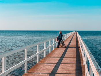 Rear view of man on sea against sky