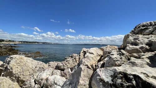 Rocks on beach against blue sky