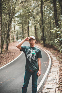 Portrait of young man standing on railroad track