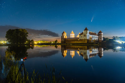 Comet neowise in a night landscape. mir castle in belarus. astronomy.