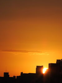 Silhouette buildings against sky during sunset