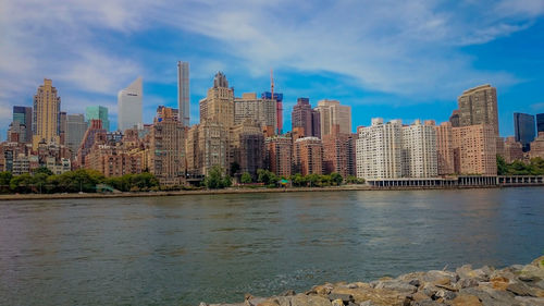 River by cityscape against sky
