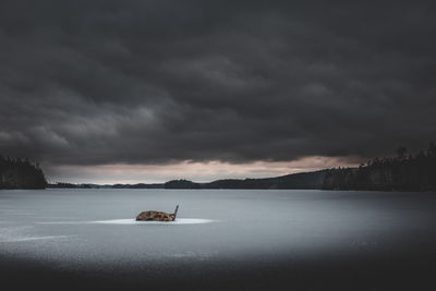 Scenic view of lake against sky during winter