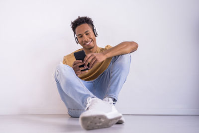 Young man using mobile phone at white background