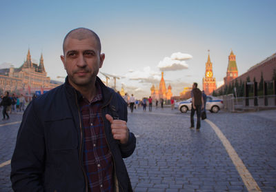 Portrait of man standing in city against sky the red square