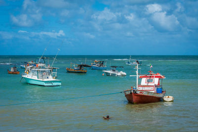 Boats moored on sea against sky