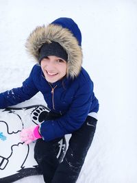 Portrait of smiling girl sitting on snow