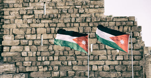 Low angle view of flag against brick wall