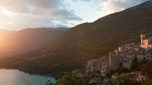 Scenic view of townscape by mountains against sky