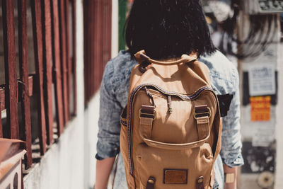 Midsection of woman wearing backpack while standing outdoors