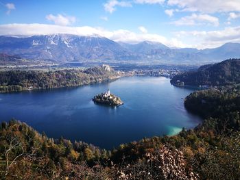 Scenic view of lake by mountains against sky