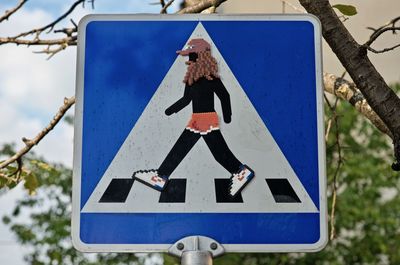 Close-up of road sign against blue sky