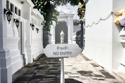 Information sign on alley amidst buildings in city