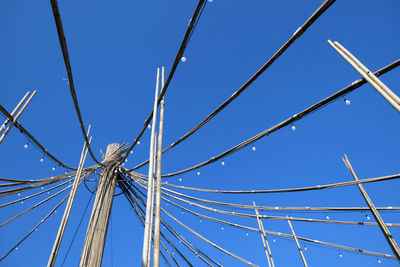 Low angle view of cables against clear blue sky