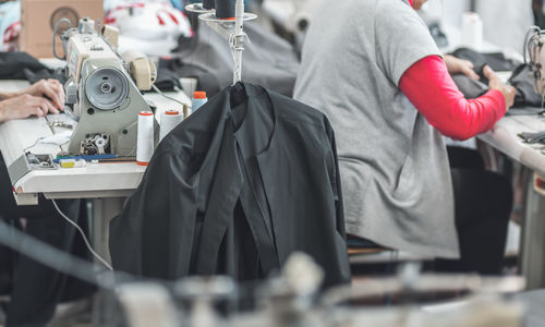 Workers working on sewing machines in clothing industry