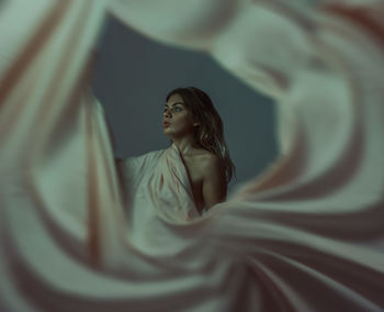 Young woman looking away over white background