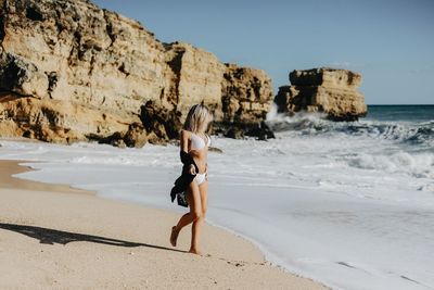 Full length of woman at beach against sky