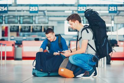 Young woman using phone while sitting at airport