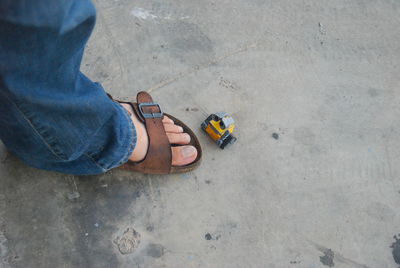 Low section of person standing by toy on floor