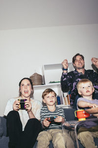 Happy family enjoying while playing video game at home