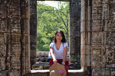 Portrait of smiling young woman sitting outdoors