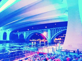 Arch bridge over river at night