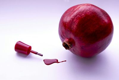 Close-up of red fruit over white background