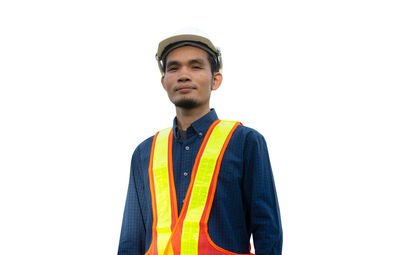 Portrait of young man standing against white background