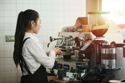 Rear view of man standing in kitchen