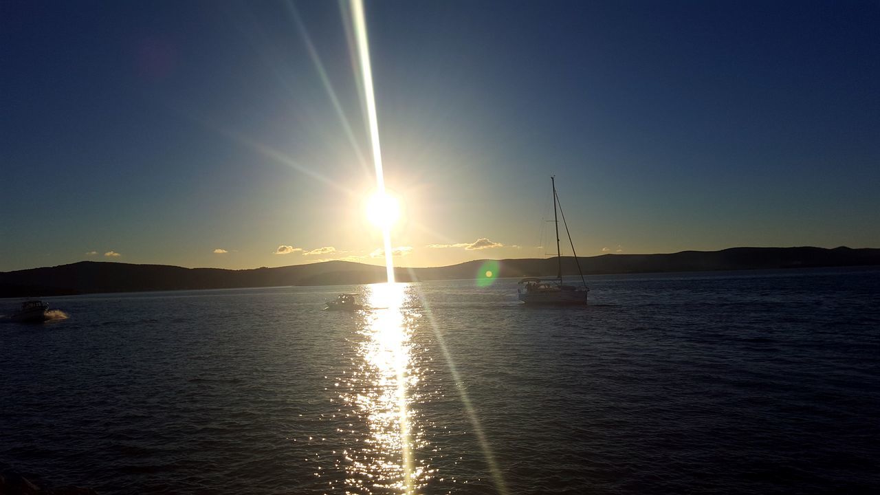 SCENIC VIEW OF SEA ON SUNNY DAY AGAINST SKY ON MOUNTAIN DURING SUNSET