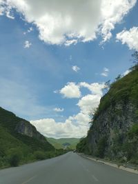 Road amidst trees against sky