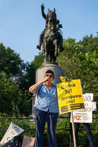 Man standing by statue against plants