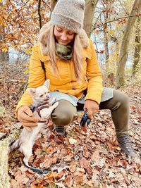 Midsection of woman with umbrella on leaves during winter