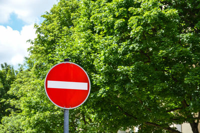 Low angle view of road sign against trees