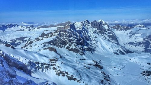 Scenic view of snow covered mountains against sky