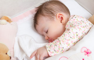 Baby girl sleeping in crib at home